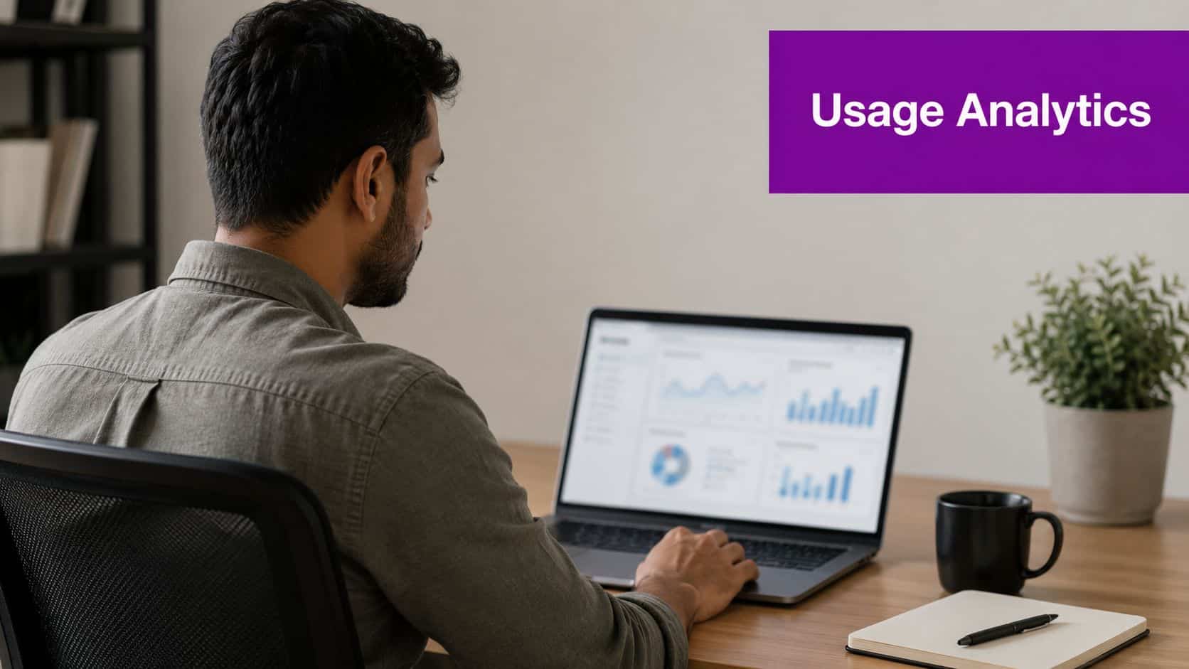 A man sitting at a desk looking at usage analytics charts on his laptop screen.